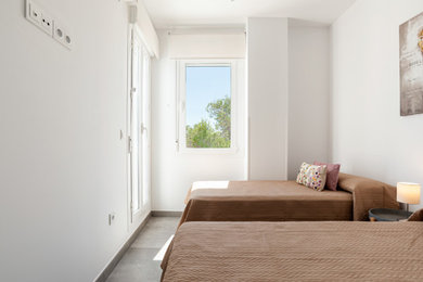 Imagen de habitación de invitados contemporánea con paredes blancas, suelo de baldosas de porcelana y suelo gris