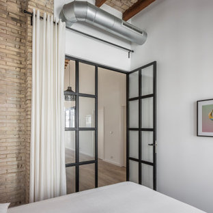 Modelo de dormitorio principal, rural, de tamaño medio, sin chimenea, con paredes beige, suelo de baldosas de porcelana y suelo beige