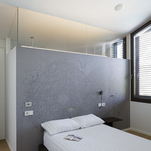 Diseño de habitación de invitados contemporánea con paredes blancas, suelo de madera en tonos medios y suelo marrón