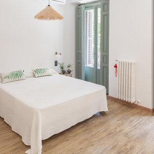 Imagen de dormitorio principal, tropical, sin chimenea, con paredes blancas y suelo beige