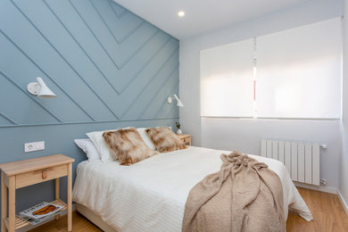 Imagen de dormitorio principal contemporáneo con paredes azules y suelo de madera en tonos medios