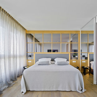 Ejemplo de dormitorio principal, actual, con paredes blancas, suelo de madera en tonos medios y suelo marrón