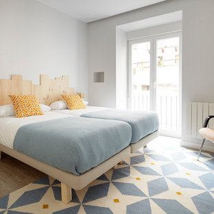 Ejemplo de dormitorio contemporáneo con suelo de madera en tonos medios, paredes grises y suelo marrón