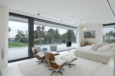 This is an example of a large contemporary master bedroom in Madrid with white walls and no fireplace.