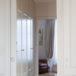 Foto de vestidor unisex, tradicional renovado, con armarios con rebordes decorativos, puertas de armario beige, suelo de madera clara y suelo marrón