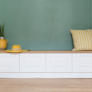Ispirazione per uno spazio per vestirsi unisex minimalista di medie dimensioni con ante con riquadro incassato, ante bianche, parquet chiaro e pavimento beige