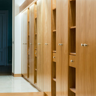 Ejemplo de vestidor unisex, tradicional renovado, grande, con armarios con rebordes decorativos, puertas de armario rojas, suelo de baldosas de cerámica y suelo beige