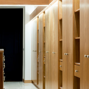 Modelo de vestidor unisex, tradicional renovado, grande, con armarios con rebordes decorativos, puertas de armario rojas, suelo de baldosas de cerámica y suelo beige
