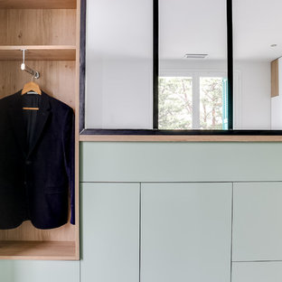 Modern inredning av ett litet walk-in-closet för könsneutrala, med öppna hyllor och gröna skåp