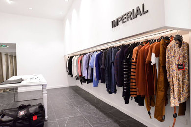 Imagen de armario vestidor unisex contemporáneo grande con armarios abiertos, puertas de armario blancas, suelo de mármol y suelo negro