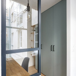 Foto de vestidor unisex, nórdico, pequeño, con armarios con paneles lisos, puertas de armario azules, suelo de madera clara y suelo beige