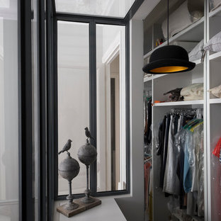 Cette photo montre un dressing et rangement tendance de taille moyenne et neutre avec un placard sans porte et des portes de placard blanches.