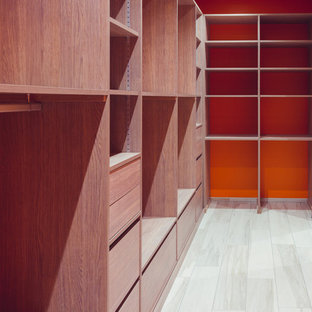 Modelo de vestidor unisex, moderno, de tamaño medio, con puertas de armario de madera clara, armarios abiertos, suelo de baldosas de cerámica y suelo blanco