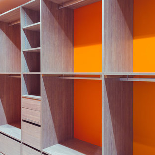 Modelo de vestidor unisex, moderno, de tamaño medio, con armarios abiertos, puertas de armario de madera clara, suelo de baldosas de cerámica y suelo blanco