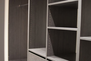 Foto de armario vestidor unisex actual grande con armarios abiertos y puertas de armario de madera en tonos medios