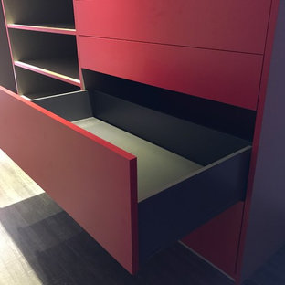 Immagine di un grande spazio per vestirsi unisex contemporaneo con parquet chiaro, pavimento beige e ante rosse