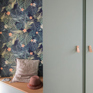 Ispirazione per una grande cabina armadio unisex nordica con ante verdi e parquet chiaro