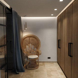 Foto di uno spazio per vestirsi per donna mediterraneo di medie dimensioni con ante lisce, ante in legno scuro, pavimento in travertino e pavimento beige