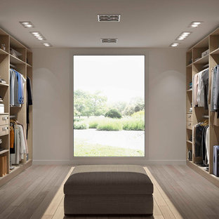 Esempio di un grande spazio per vestirsi unisex nordico con ante in legno chiaro, nessun'anta e parquet chiaro