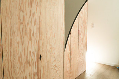 Aménagement d'un dressing moderne en bois clair de taille moyenne pour une femme avec un placard à porte affleurante, parquet clair et un sol beige.