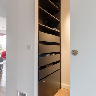 Foto di un piccolo spazio per vestirsi unisex design con nessun'anta, ante nere, parquet chiaro e pavimento beige