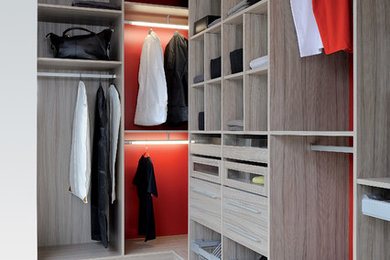 Cette image montre un dressing design en bois clair neutre et de taille moyenne avec un placard sans porte.