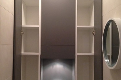 Cette photo montre un petit placard dressing tendance neutre avec un placard à porte plane, des portes de placard grises et un sol en carrelage de céramique.