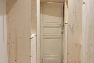 Idée de décoration pour un petit dressing room design en bois clair neutre avec un placard à porte affleurante et un sol beige.