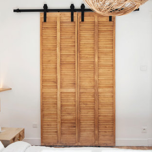 Foto di un piccolo spazio per vestirsi unisex industriale con ante a persiana, ante in legno chiaro, parquet chiaro e pavimento beige