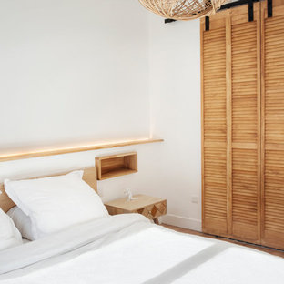 Ispirazione per un piccolo spazio per vestirsi unisex industriale con ante a persiana, ante in legno chiaro, parquet chiaro e pavimento beige