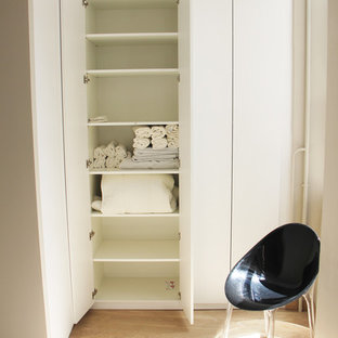 Foto de armario unisex, vintage, pequeño, con armarios con rebordes decorativos, puertas de armario blancas, suelo de madera clara y suelo beige