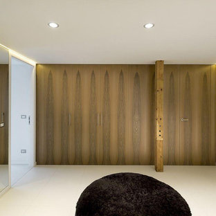 Foto de armario y vestidor moderno, grande, con armarios con rebordes decorativos, puertas de armario de madera en tonos medios, suelo de cemento y suelo beige
