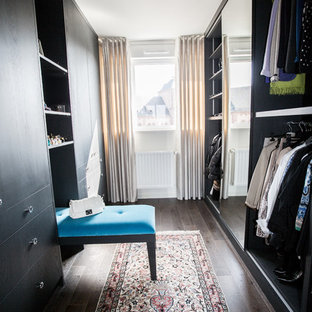 Cette photo montre un grand dressing room chic neutre avec des portes de placard en bois sombre et un sol en bois foncé.