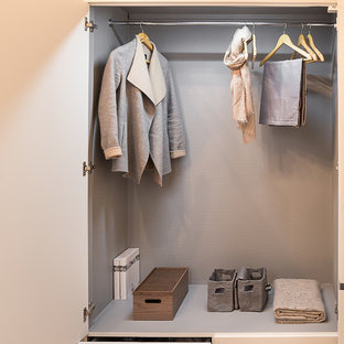 Cette image montre un placard dressing design de taille moyenne pour une femme avec un placard à porte plane et des portes de placard blanches.