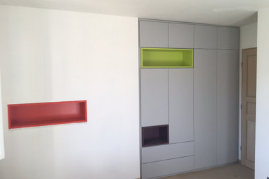 Foto de armario unisex moderno de tamaño medio con armarios con rebordes decorativos y puertas de armario grises
