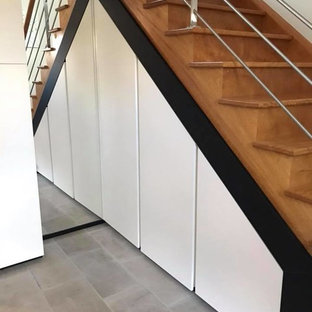 Imagen de armario unisex, minimalista, de tamaño medio, con armarios con rebordes decorativos, puertas de armario blancas, suelo de baldosas de cerámica y suelo gris