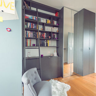 Foto di un armadio o armadio a muro per donna industriale di medie dimensioni con ante a filo, ante grigie e parquet chiaro