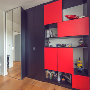Ispirazione per un armadio o armadio a muro per uomo design di medie dimensioni con ante a filo, ante nere e parquet chiaro