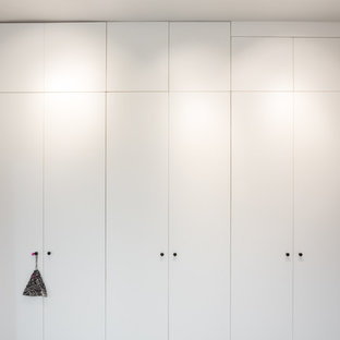 Diseño de armario unisex, minimalista, de tamaño medio, con armarios con rebordes decorativos y puertas de armario blancas