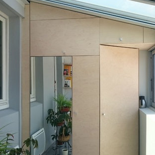 Bild på ett litet skandinaviskt klädskåp för könsneutrala, med skåp i ljust trä och linoleumgolv