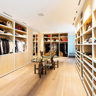 Idées déco pour un grand dressing contemporain neutre avec un sol en bois clair et un sol marron.