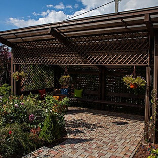 Ispirazione per un patio o portico country di medie dimensioni e davanti casa con pavimentazioni in cemento e un tetto a sbalzo