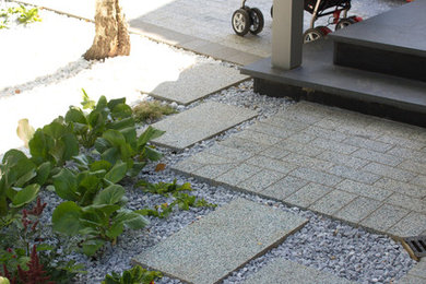 Ejemplo de patio actual pequeño sin cubierta en patio delantero con adoquines de piedra natural