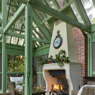 Cette image montre une terrasse traditionnelle de taille moyenne avec des pavés en pierre naturelle, une pergola et une cheminée.