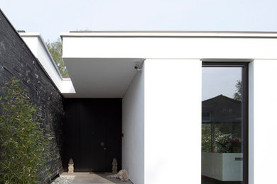 Mittelgroße Moderne Haustür mit weißer Wandfarbe, schwarzer Haustür und grauem Boden in Hamburg