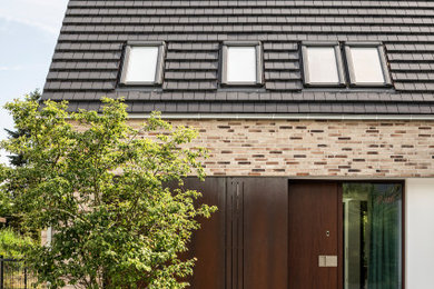 Moderner Eingang mit Einzeltür, brauner Haustür und grauem Boden in Sonstige