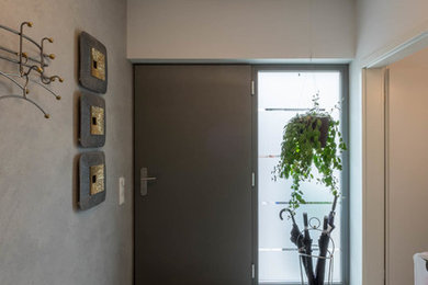 Kleiner Moderner Eingang mit Korridor, weißer Wandfarbe, Keramikboden, schwarzer Haustür und grauem Boden in Sonstige