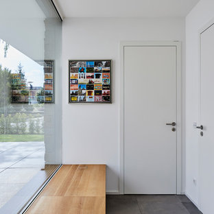Kleiner Country Eingang mit Korridor, weißer Wandfarbe, Einzeltür, weißer Tür und grauem Boden in Köln