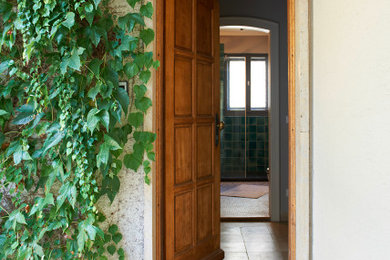 Foto de puerta principal ecléctica pequeña con paredes grises, suelo de piedra caliza, puerta simple, puerta de madera oscura y suelo beige