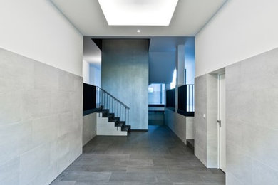 Photo of a large contemporary foyer in Cologne with metallic walls and ceramic flooring.